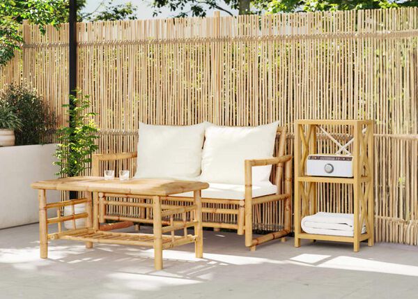 Bamboo outdoor sofa with cushions and matching coffee table in a styled terrace setting.