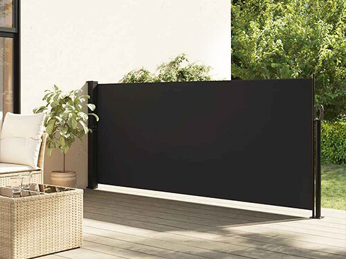 Retractable black side awning installed on a styled patio beside outdoor seating and a potted plant. Click to see the products in the collection.