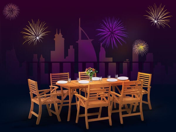 Wooden outdoor dining set with plates and flowers on a terrace, city skyline and fireworks in the background. Click to see the products in the collection.
