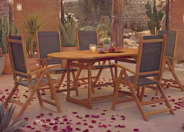 Outdoor dining set with wooden table and chairs, surrounded by potted plants and scattered rose petals.