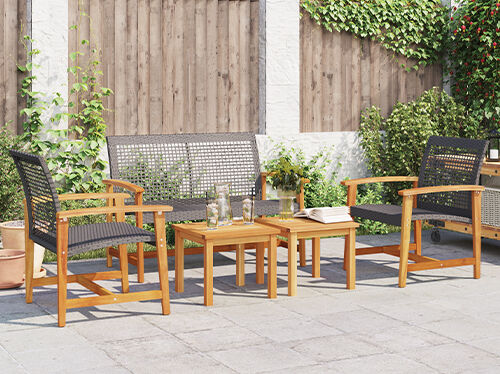 Dark metal 2-seater outdoor sofa and coffee table on patio. Furniture set against wooden fence with decorative string lights. Click to see new arrivals.